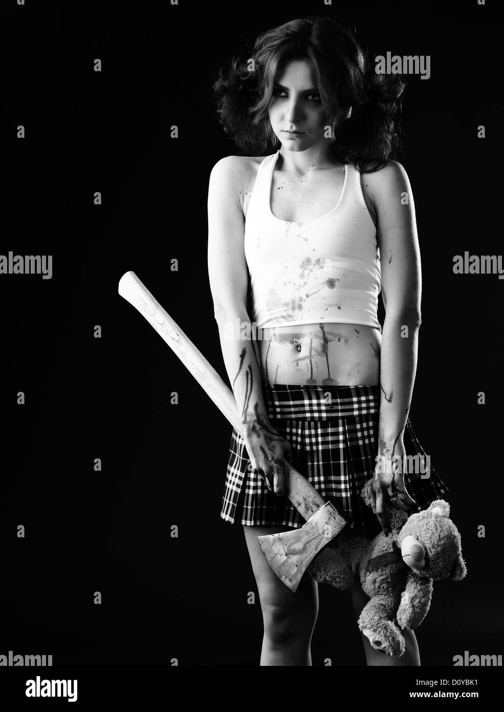 studio shot on black background: young woman holding bloody axe (axe girl) Stock Photo