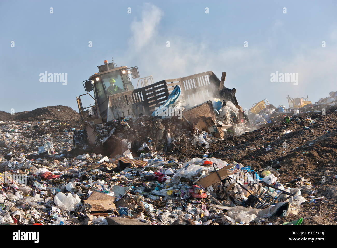 Bulldozer 'track laying' pushing trash at landfill, California Stock Photo
