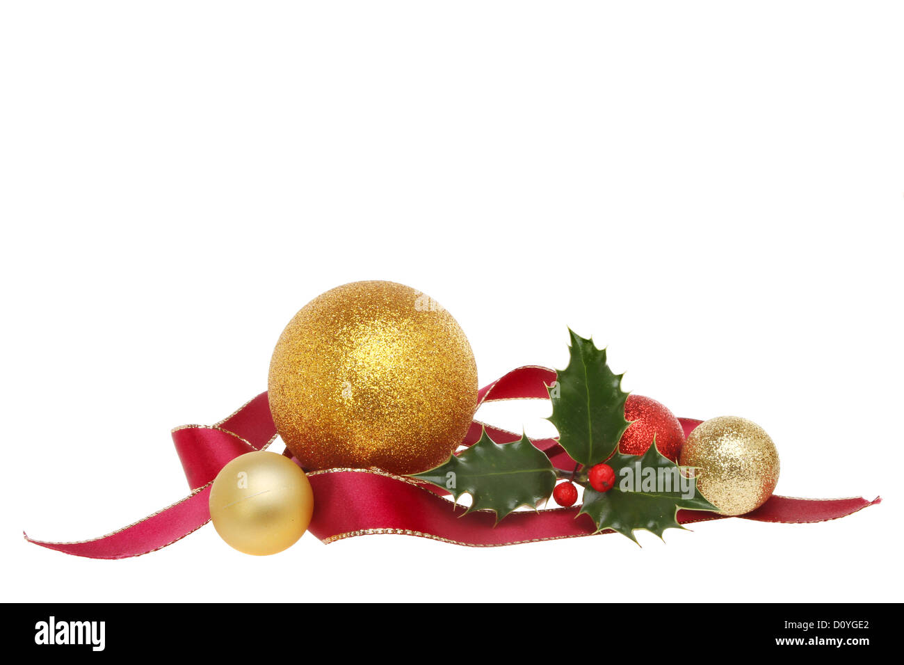 Ribbon, bauble and holly Christmas decoration isolated against white Stock Photo