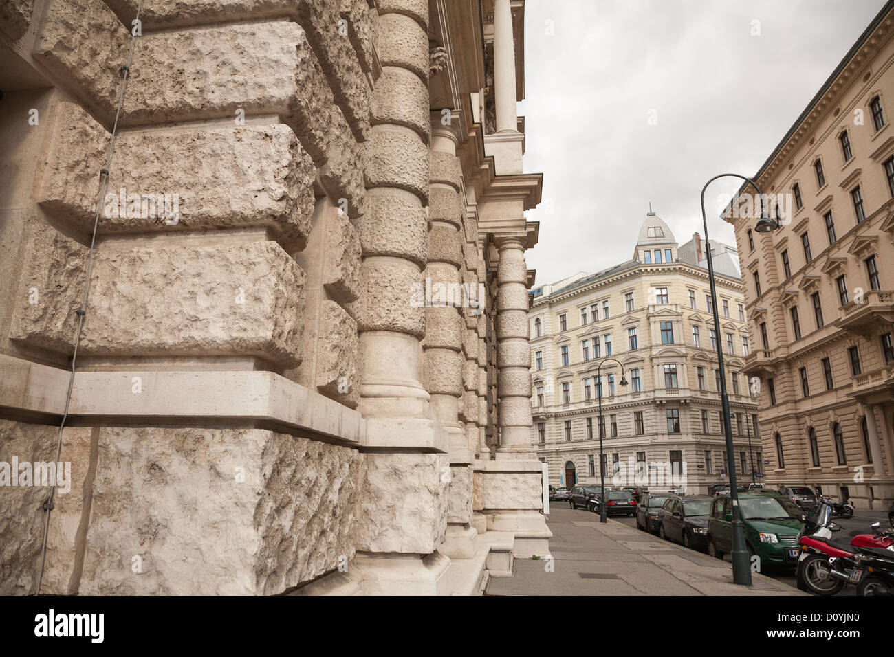 An empty street in Vienna on an overcast day, the cream facades of old multistory buildings made of out large pieces of stone. Stock Photo