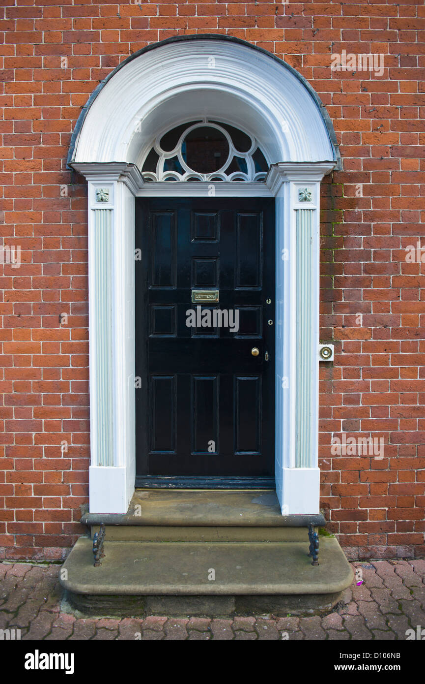 Black Paneled Wooden Front Door With Brass Letter Box And Fanlight