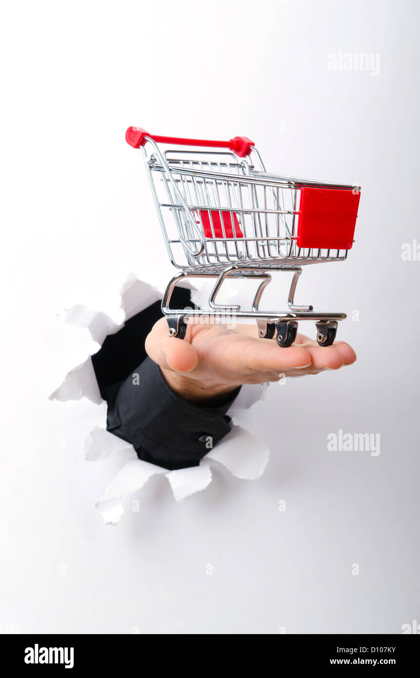 Shopping cart through hole in paper Stock Photo Alamy