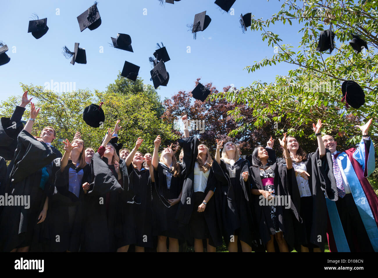 Graduates from the Engineering School of the University of Southampton, England, try to catch their mortar boards. Stock Photo