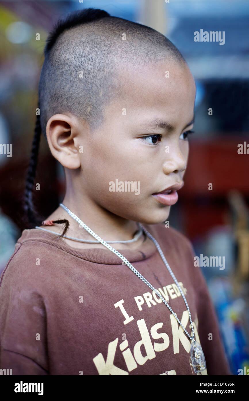 Traditional top knot shaven head hairstyle on a Thai young boy ...