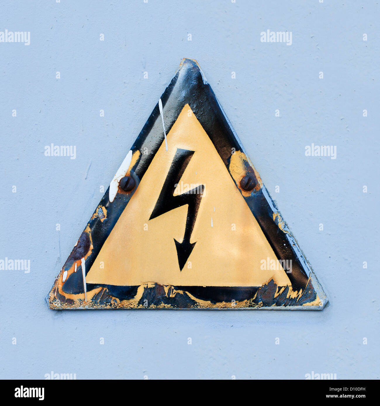 Warning safety sign 'Danger of electric shock'. Old sign on a blue background Stock Photo