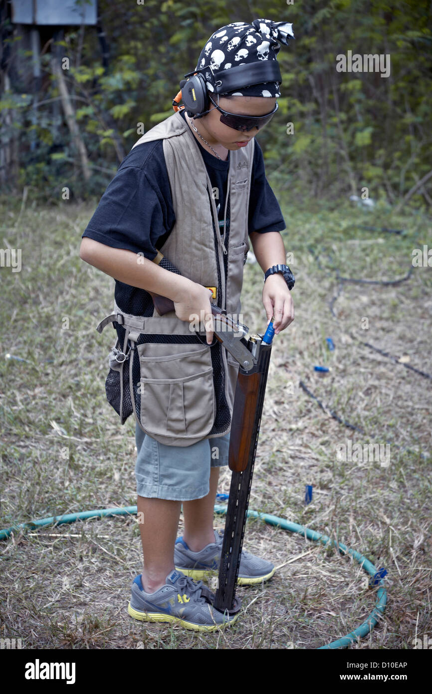Boy shotgun. Young boy reloading a shotgun at a clay pigeon shoot Stock