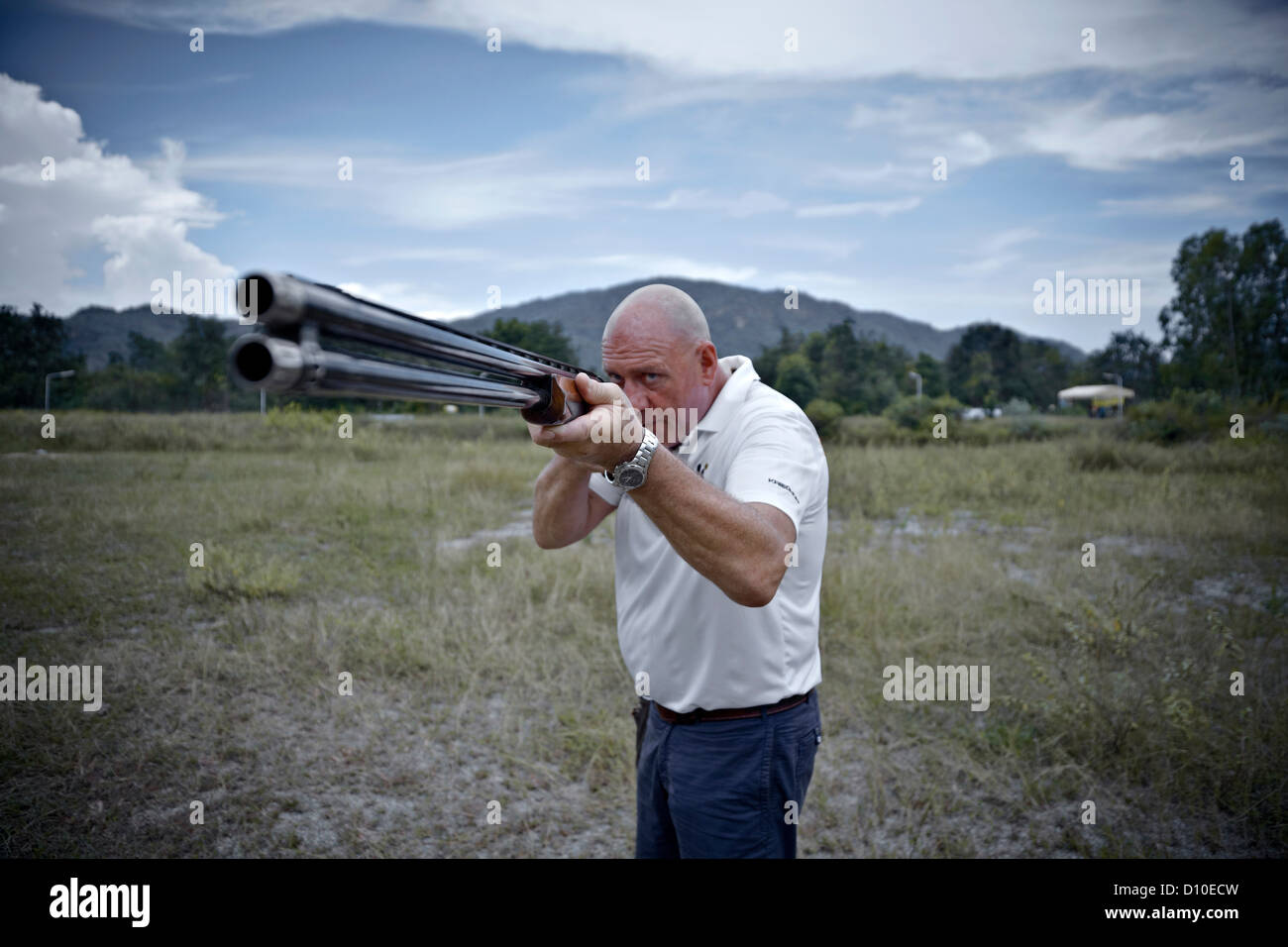 Man taking aim with shotgun Stock Photo