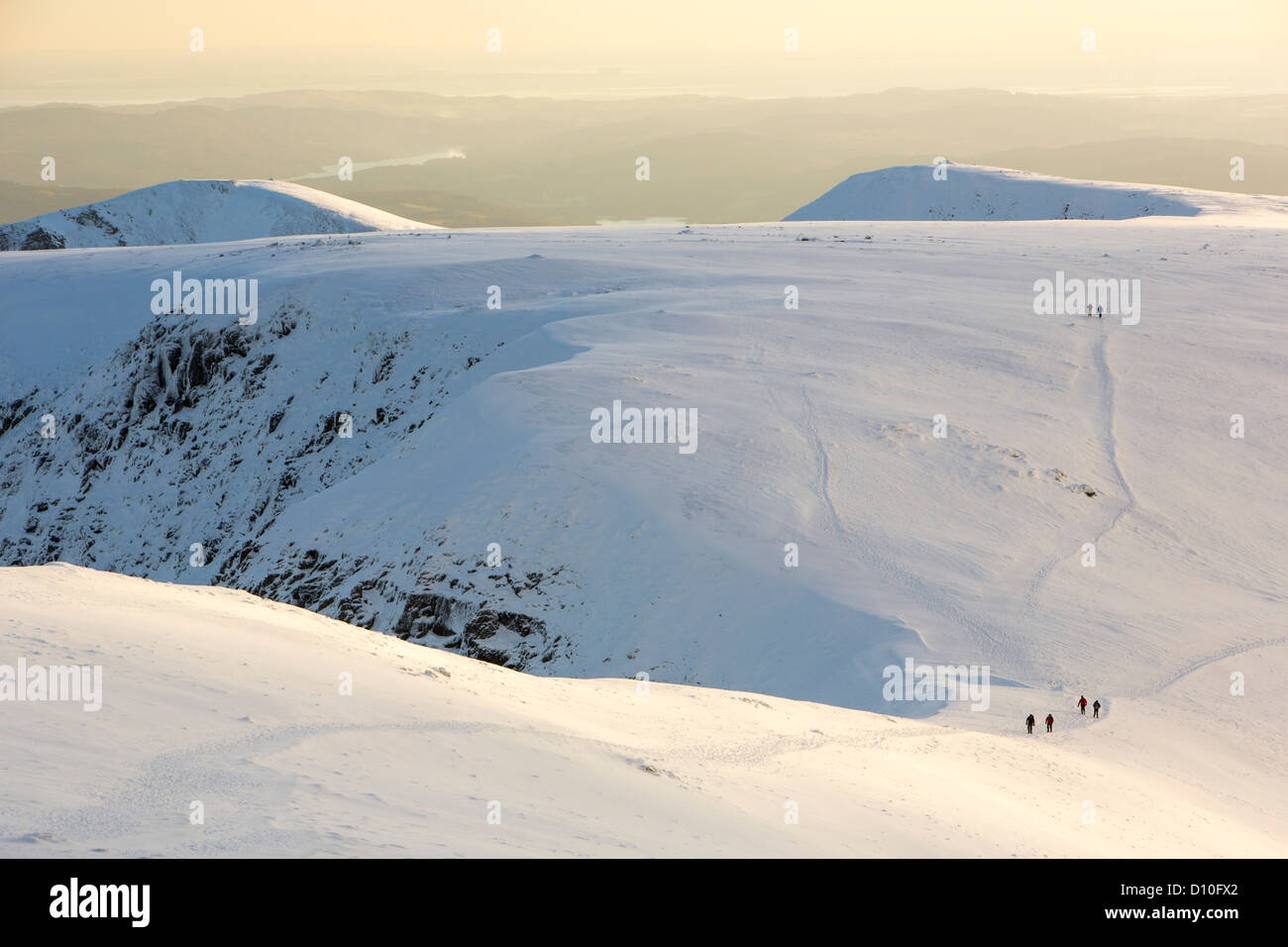 Walkers on Helvellyn in the snow, Lake District, UK. Stock Photo
