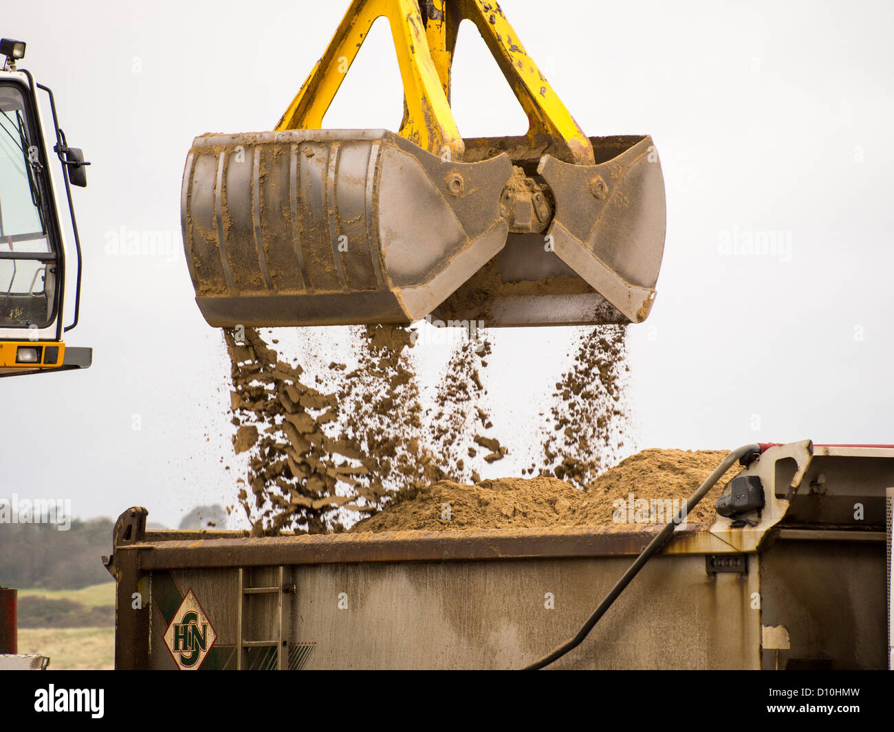 Sand dredged from the Camel Estuary being loaded onto trucks at Padstow harbour, Cornwall, UK. Stock Photo