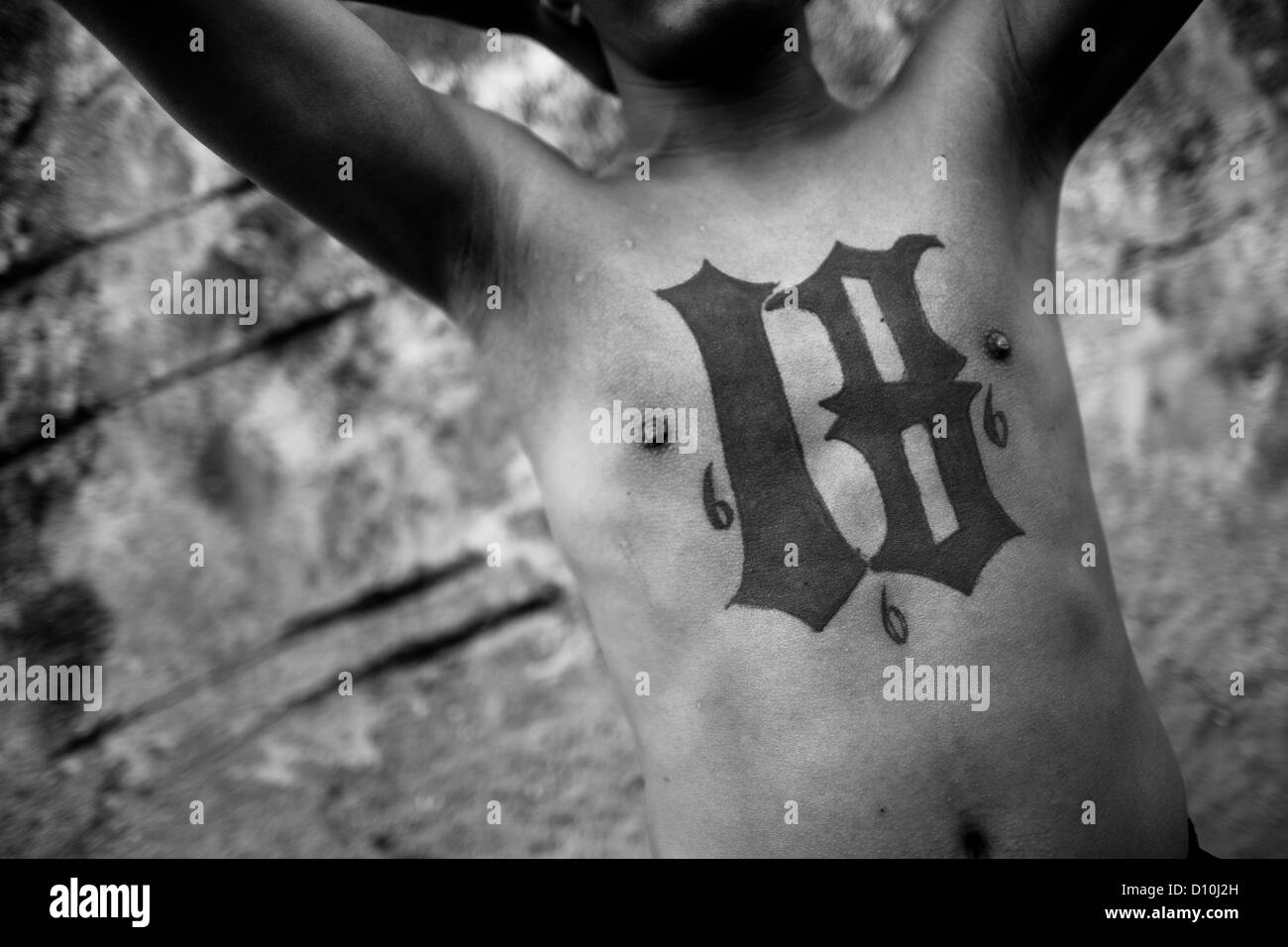 A member of the 18th Street Gang (M-18) shows off his gang tattoos in San Salvador, El Salvador. Stock Photo