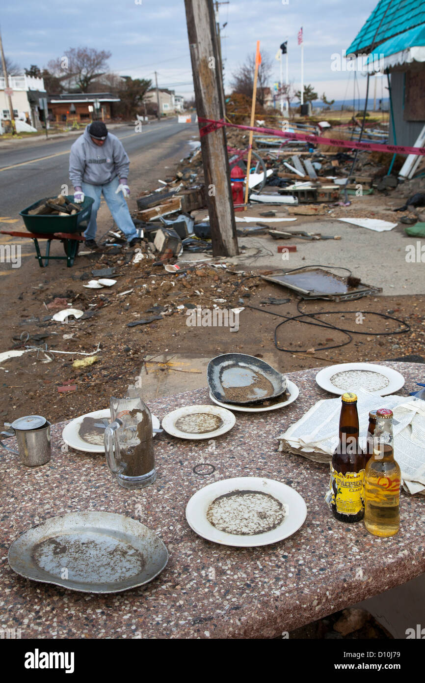 Union Beach, New Jersey - A man cleans up outside Jakeabob's Bay waterfront restaurant, heavily damaged by Hurricane Sandy. Stock Photo