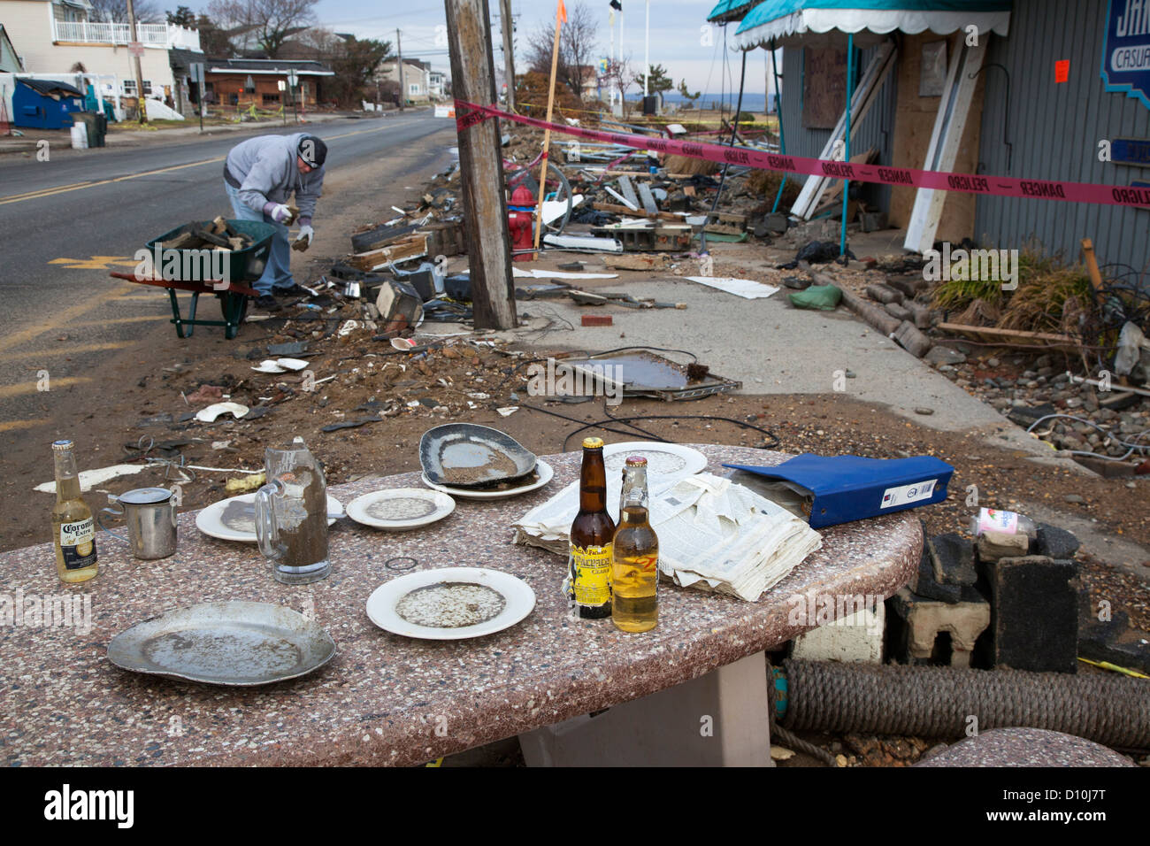 Union Beach, New Jersey - A man cleans up outside Jakeabob's Bay waterfront restaurant, heavily damaged by Hurricane Sandy. Stock Photo