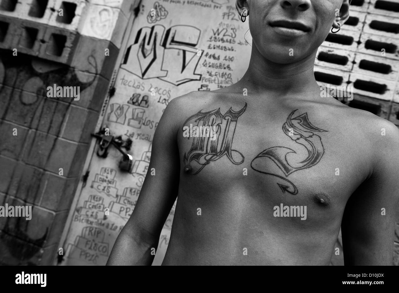 A member of the Mara Salvatrucha gang (MS-13) shows off his gang tattoos in the prison of Tonacatepeque, El Salvador. Stock Photo