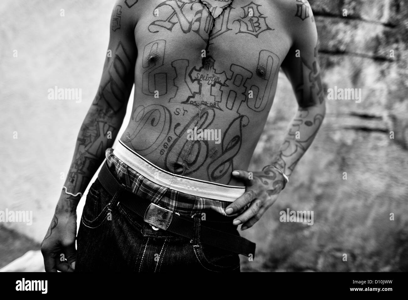 A member of the 18th Street Gang (M-18) proudly shows off his gang tattoos in San Salvador, El Salvador. Stock Photo