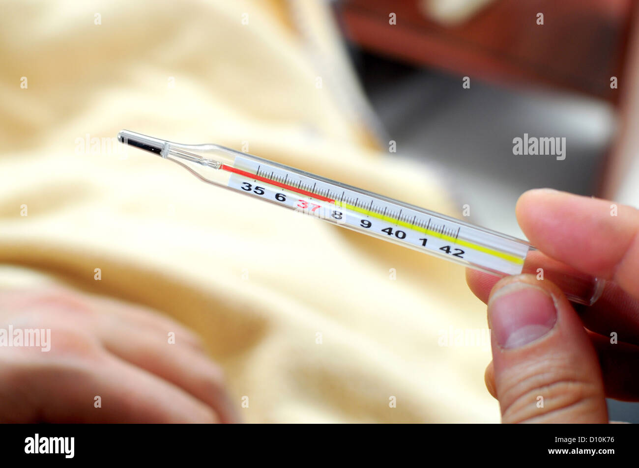 Hand holding thermometer showing fever Stock Photo
