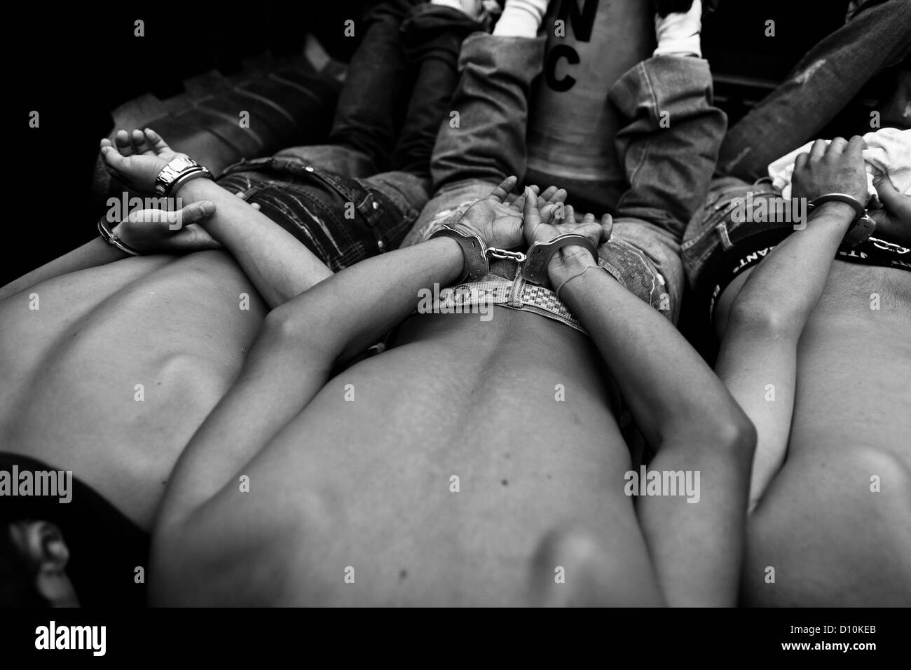 Young men, supposed gang members, lie handcuffed in the Police pick-up truck in San Salvador, El Salvador. Stock Photo