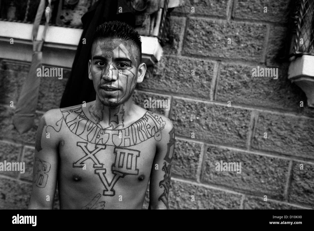 A former member of the 18th Street Gang (M-18) shows off his gang tattoos on the street in San Salvador, El Salvador. Stock Photo