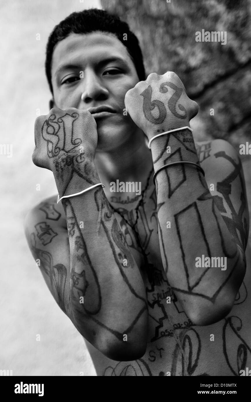 A member of the 18th Street Gang (M-18) proudly shows off his gang tattoos in San Salvador, El Salvador. Stock Photo