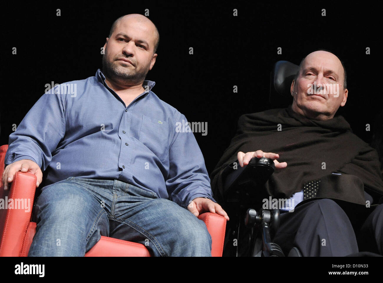 Abdel Sellou (L) and Philippe Pozzo di Borgo sit next to each other during  a reading session on stage in the Columbiahalle arts and concert venue in  Berlin, Germany, 3 December 2012.