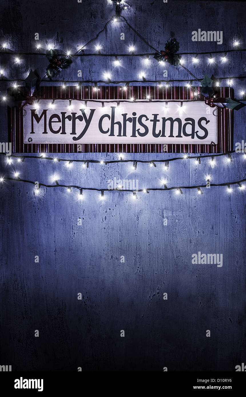 Image of beautiful Christmastime home decoration, Merry Christmas banner hanging on the door decorated with festive lights Stock Photo
