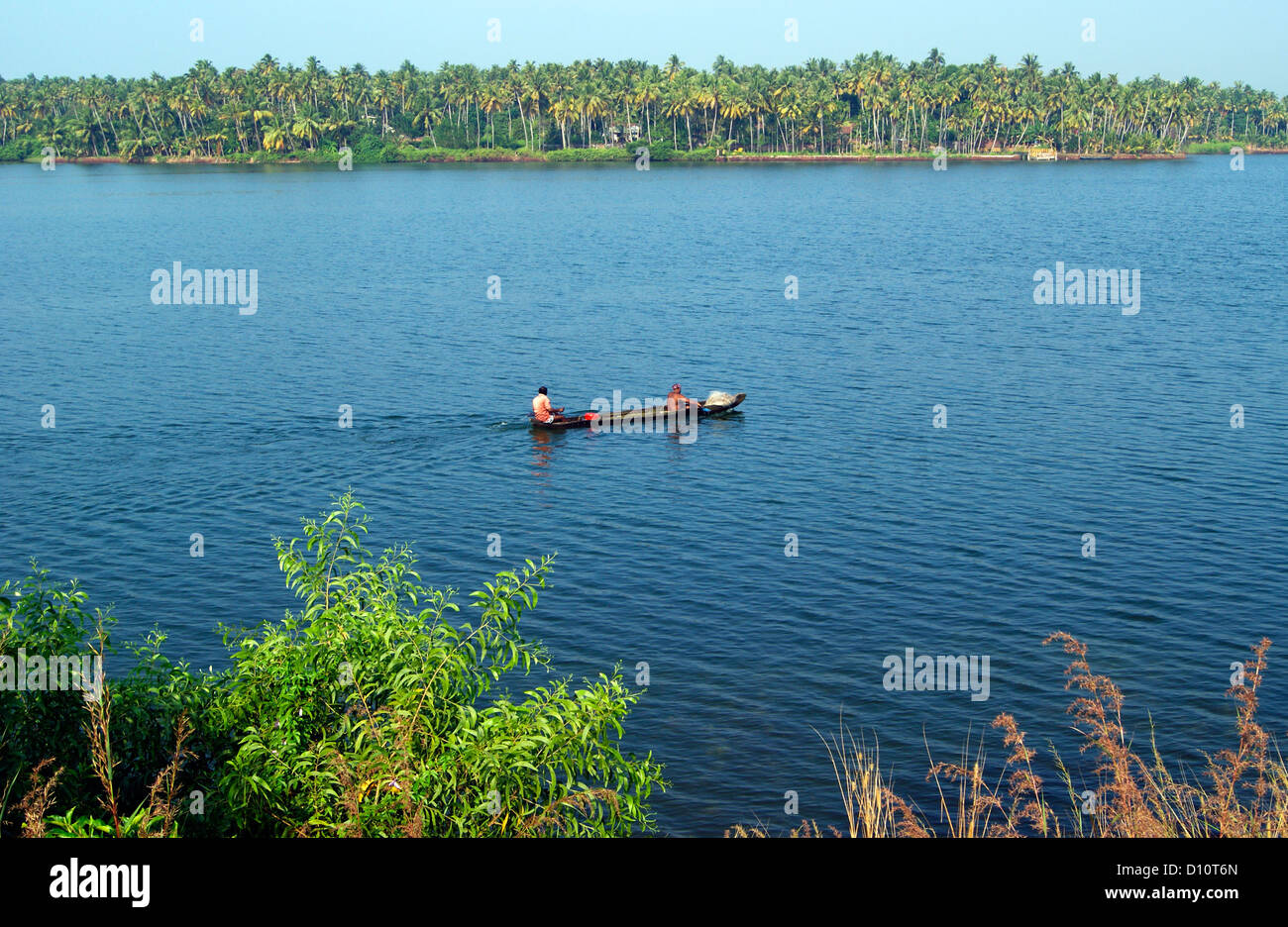 Small wooden canoe boat sailing through the Kerala Backwaters at India
