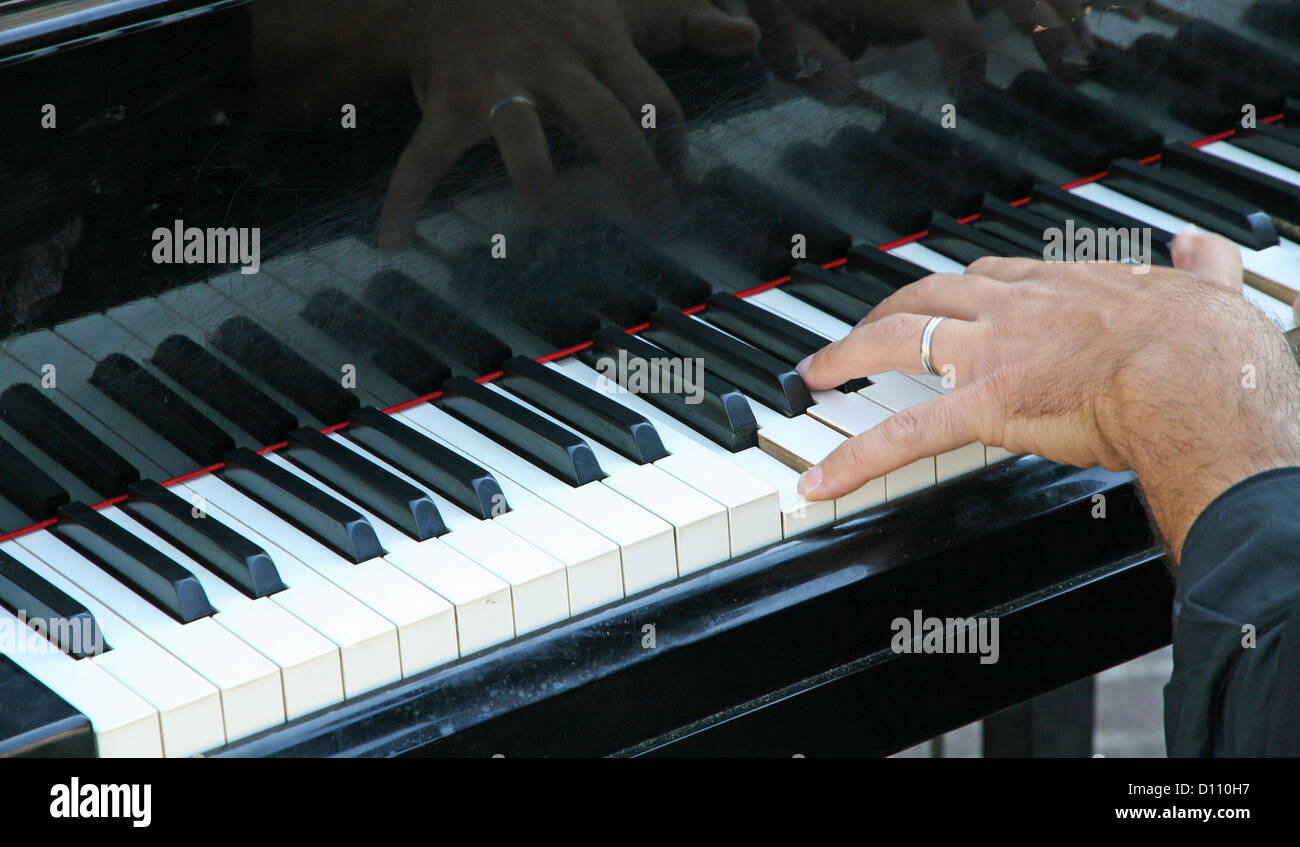 hand of a pianist with a ring that plays the white and black keys on