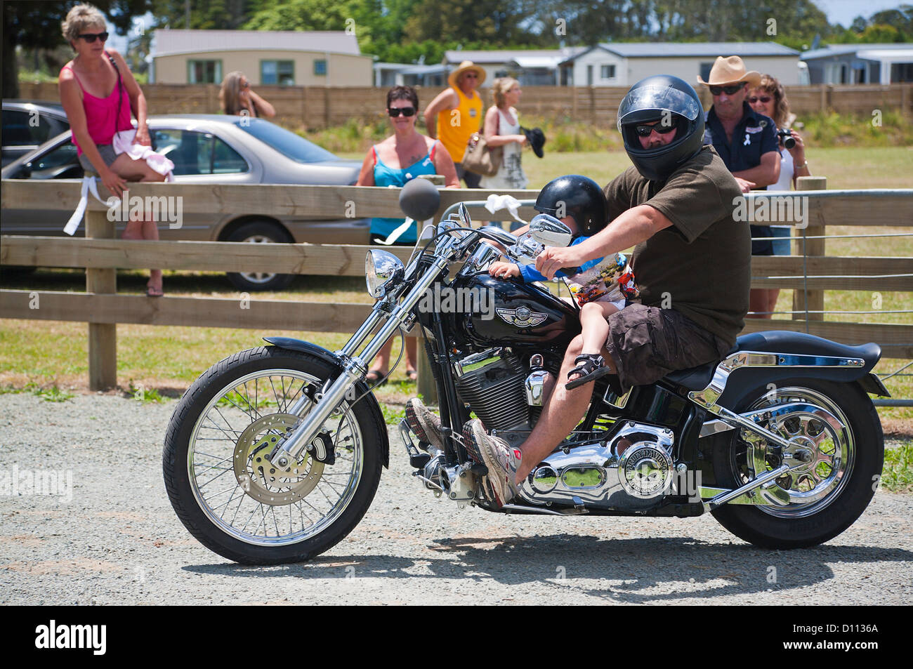 A man and a young child riding a Harley Davidson motorcycle. Motorbikes in Mangawhai, Northland, North Island, New Zealand. Stock Photo