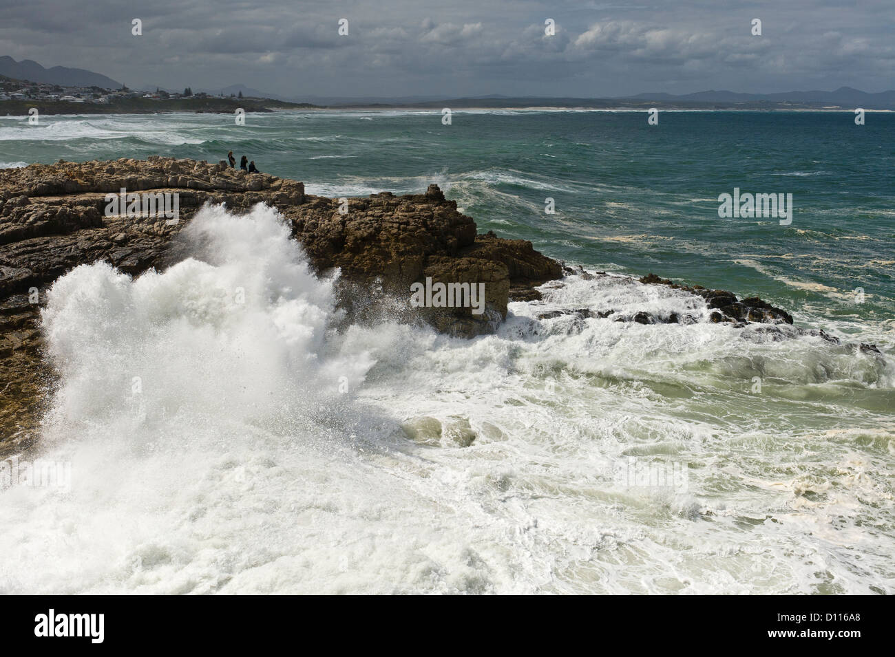 People watching waves crushing on the rocks, Hermanus, South Africa Stock Photo