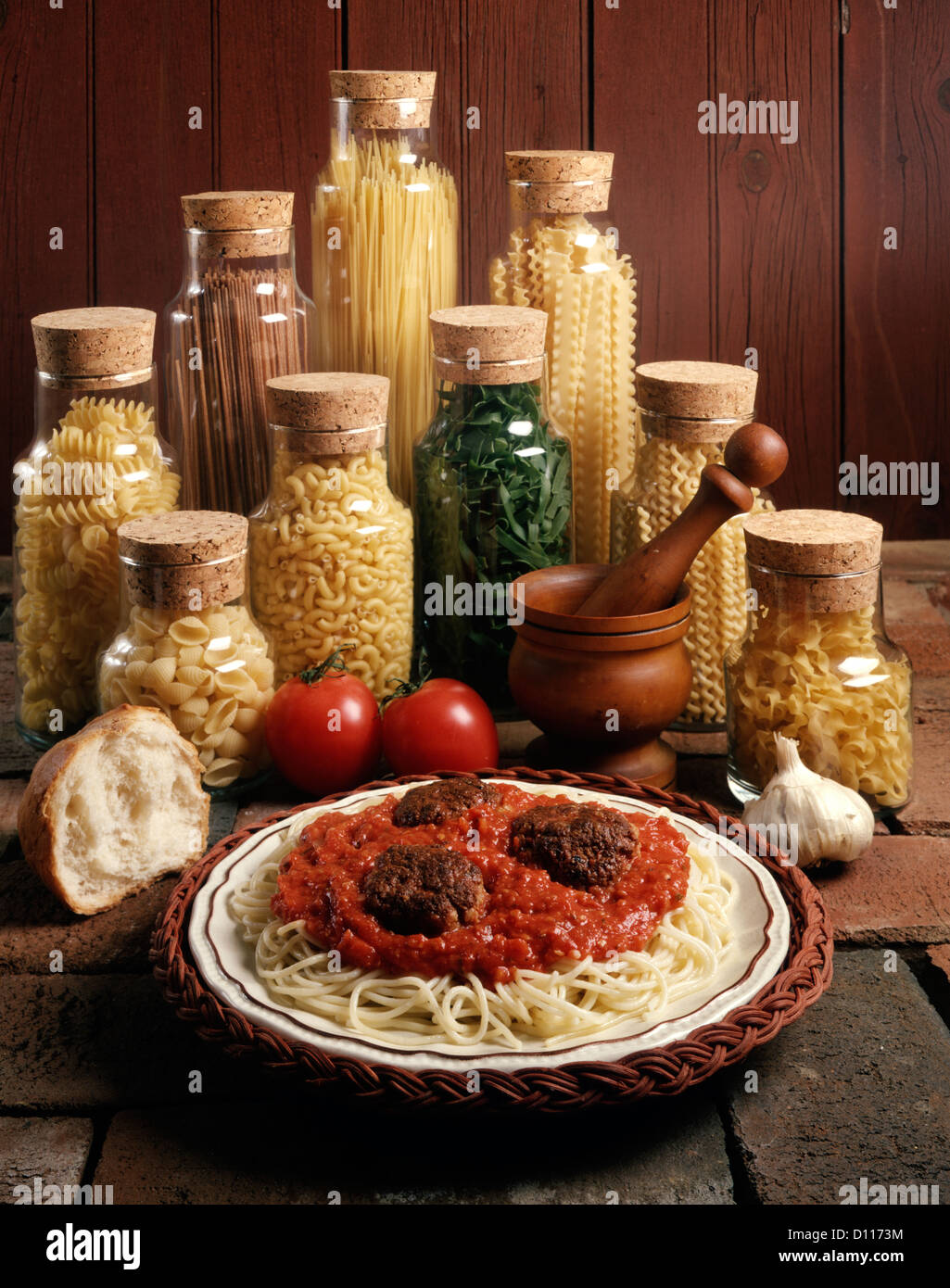 1980s DISH OF SPAGHETTI AND MEATBALLS WITH JARS OF PASTA NOODLES Stock Photo