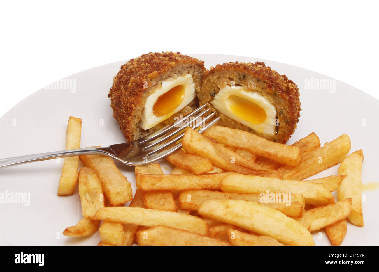 Runny Scotch egg and French fries on a plate with a fork Stock Photo