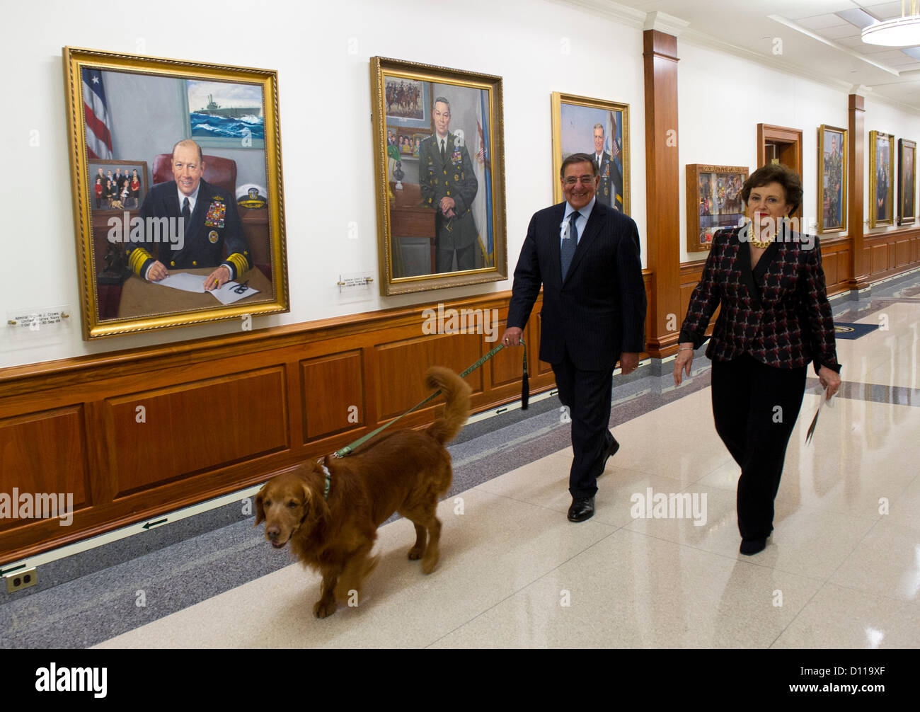 US Secretary of Defense Leon Panetta and his wife Sylvia with Bravo walk through the corridors of the Pentagon before taping a holiday message to the troops at the Pentagon, December 4 2012 in Arlington, VA. Stock Photo