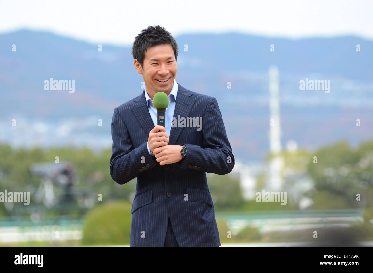 Japanese racing driver Kamui Kobayashi speaks during a special appearance at Hanshin racecourse in Japan on 2nd December, 2012. Stock Photo