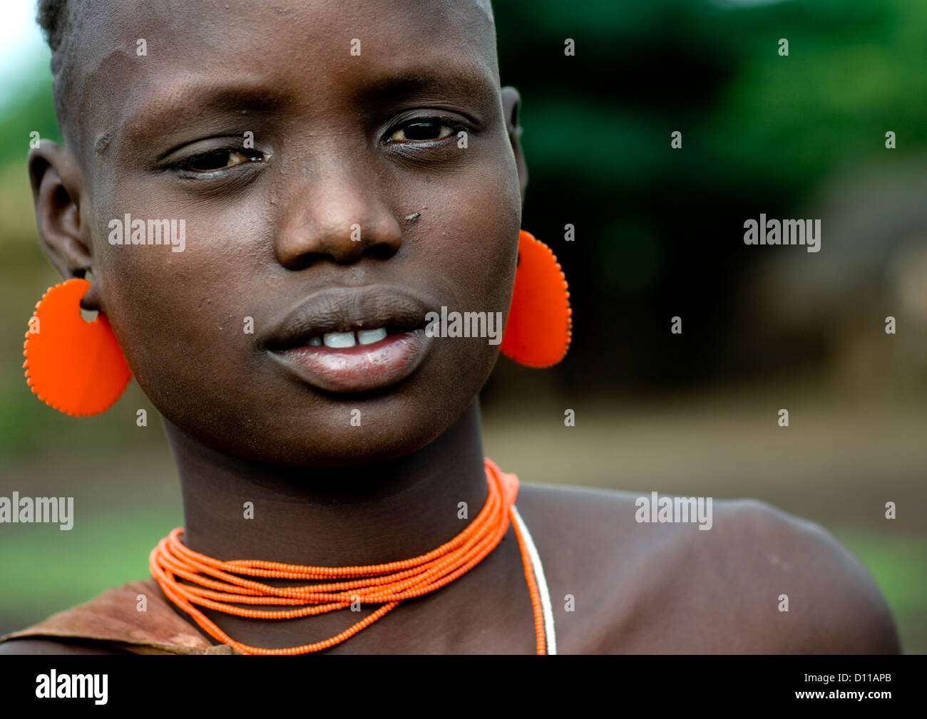 Portrait Of A Young Bodi Tribe Girl With Orange Jewels, Hana Mursi, Omo Valley, Ethiopia Stock Photo