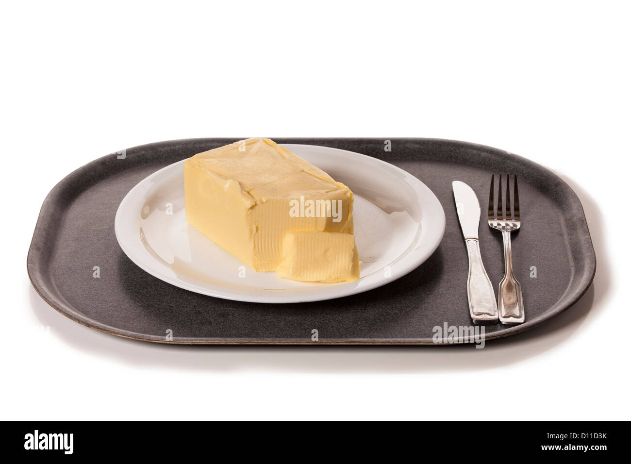 Block of butter on a plate, time to eat an unhealthy dinner. Stock Photo