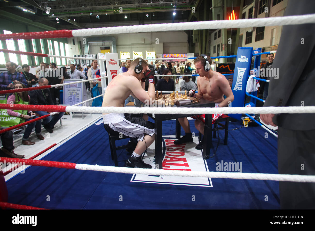 Chess boxers Arik Braun (R) and Felix Bartels sit in front of a chequer  board during the Chess Boxing Championships in Berlin, Germany, 28 July  2012. The chess boxing event took place