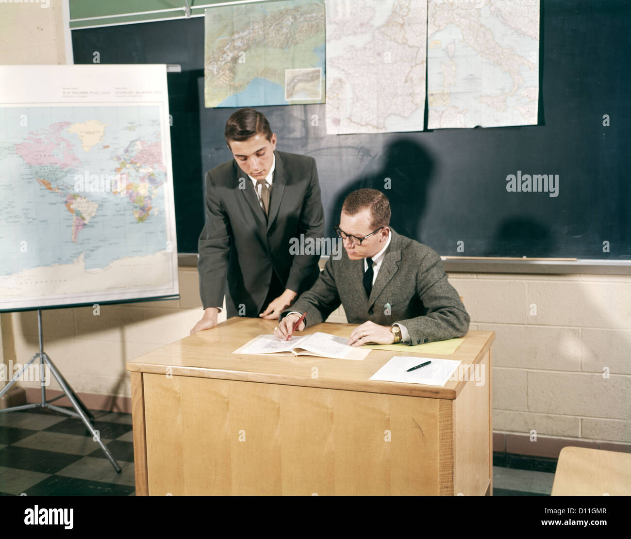 1960s TEACHER STUDENT CONFERENCE DESK MAPS HIGH SCHOOL Stock Photo