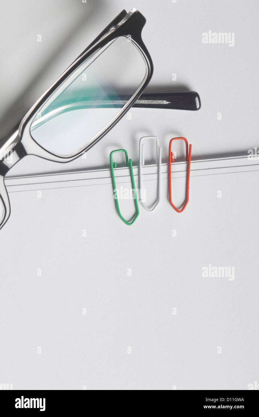 Three paper clips with spectacles in Italian national colours against white background Stock Photo