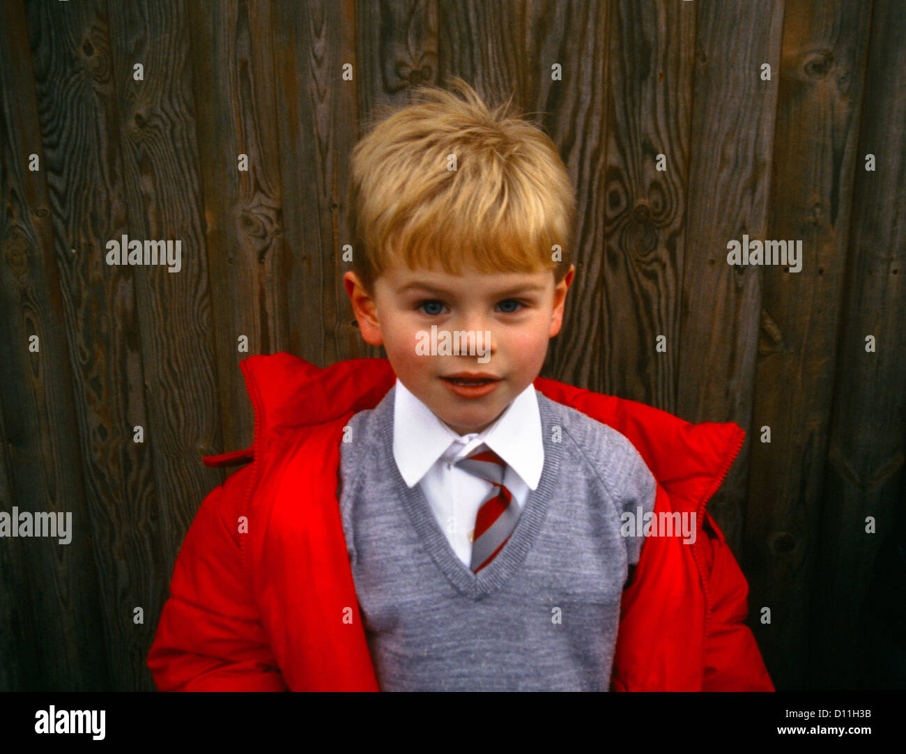 Portrait of Boy 6 Years wearing School Uniform and Red coat Stock Photo