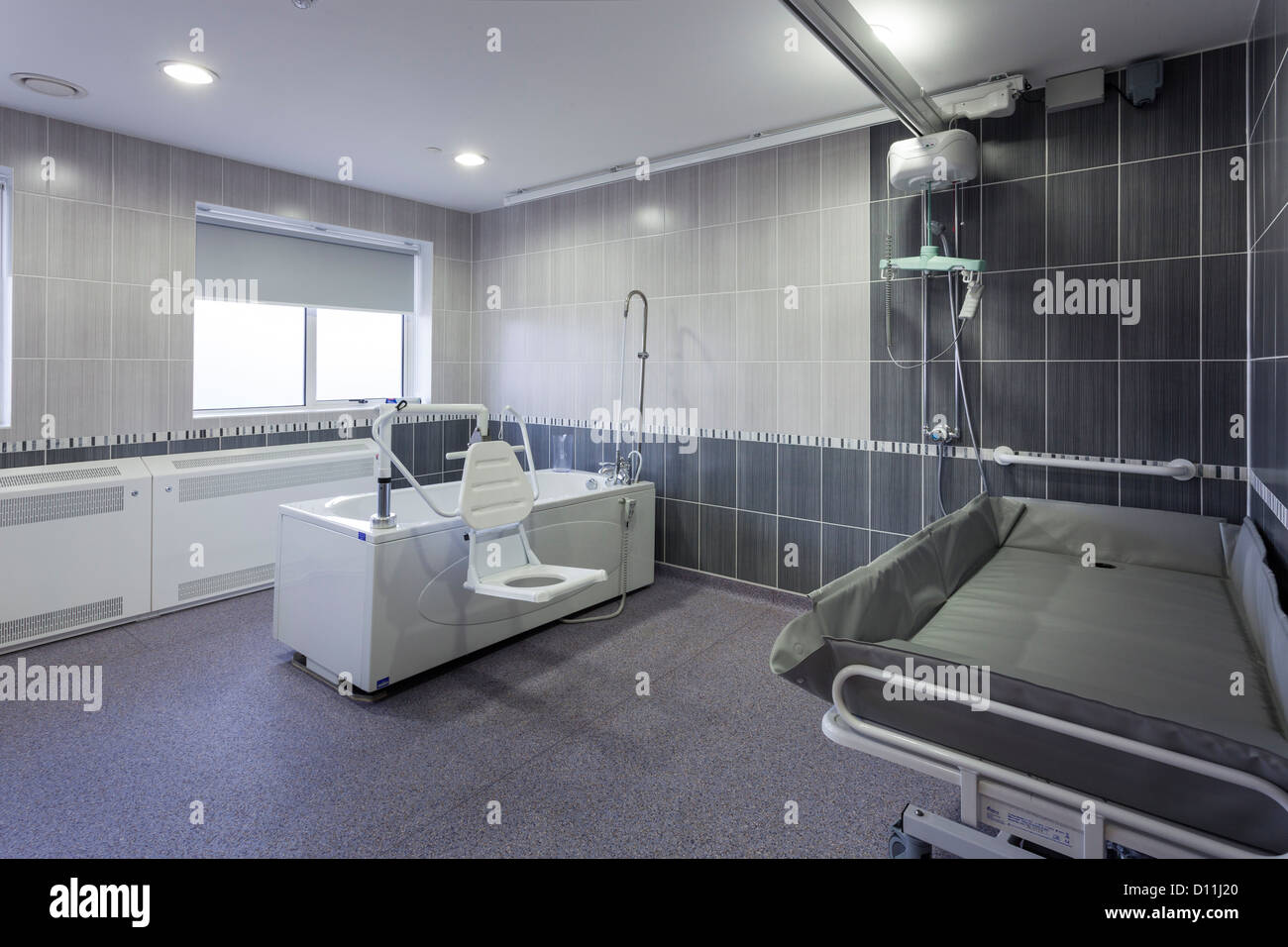 Care home assisted bathroom with ceiling track hoist lifting gear Stock Photo