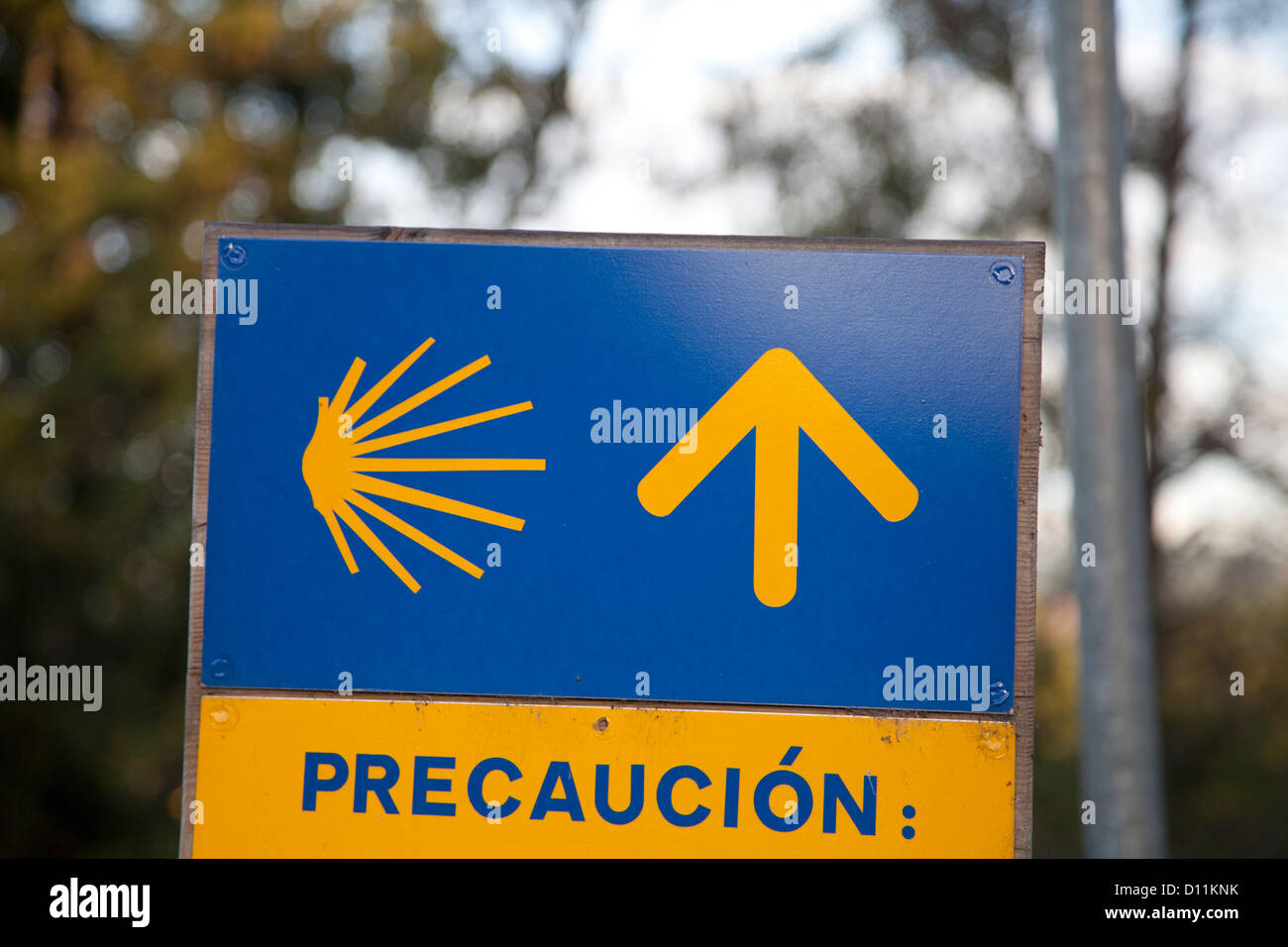 Camino precaution sign, with stylized scallop shell and yellow arrow. Often seen just before the pilgrim path crossed a road Stock Photo