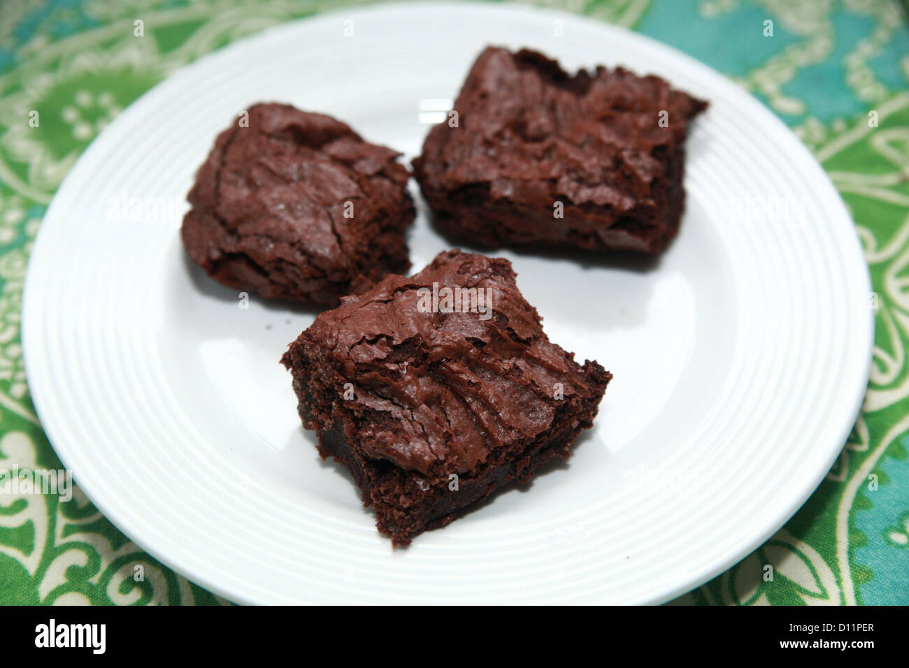 Three homemade brownies on a white plate Stock Photo