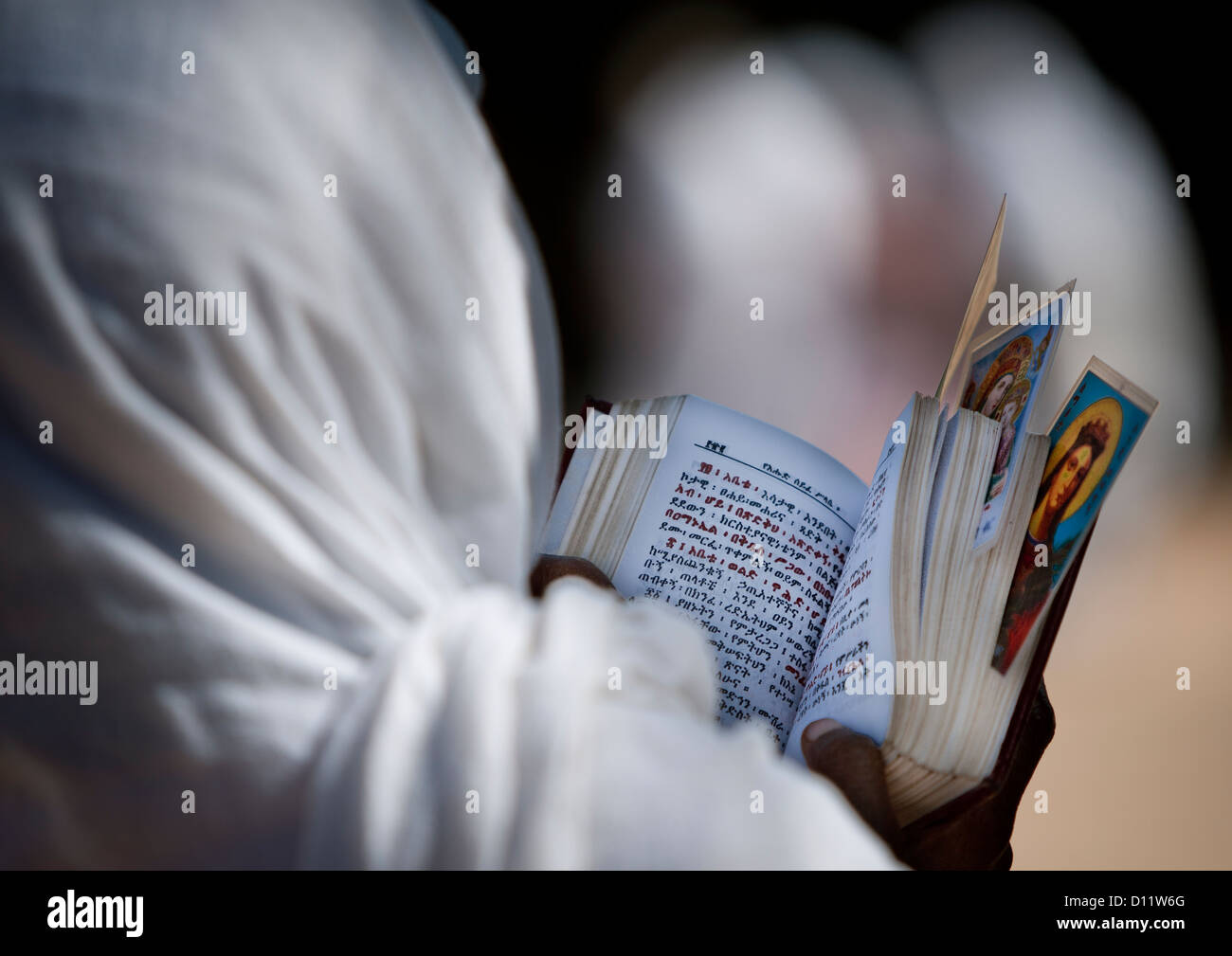 Rear View Of An Orthodox Woman Praying With A Bible In Church, Harar, Ethiopia Stock Photo