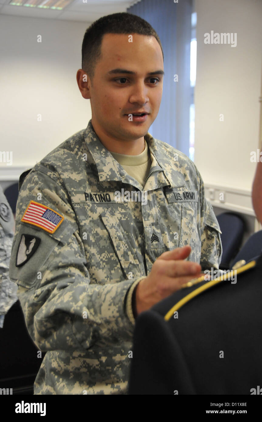 U.S. Army Sgt. Johan Patino with Engineer Troop, 4th Squadron, 2nd Cavalry Regiment inspects a uniform for deficiencies during the Regiment's Non Commissioned Officer/Soldier of the Year competition 4 Dec. 2012 at Rose Barracks, Germany. Stock Photo