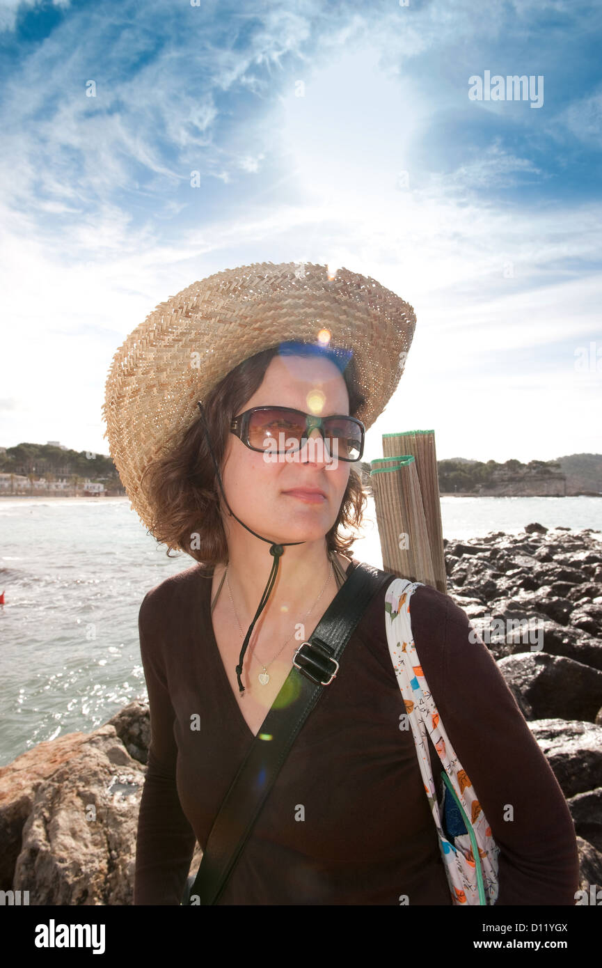 Peguera, Majorca, Spain, a woman with a straw hat and sunglasses on the beach Stock Photo