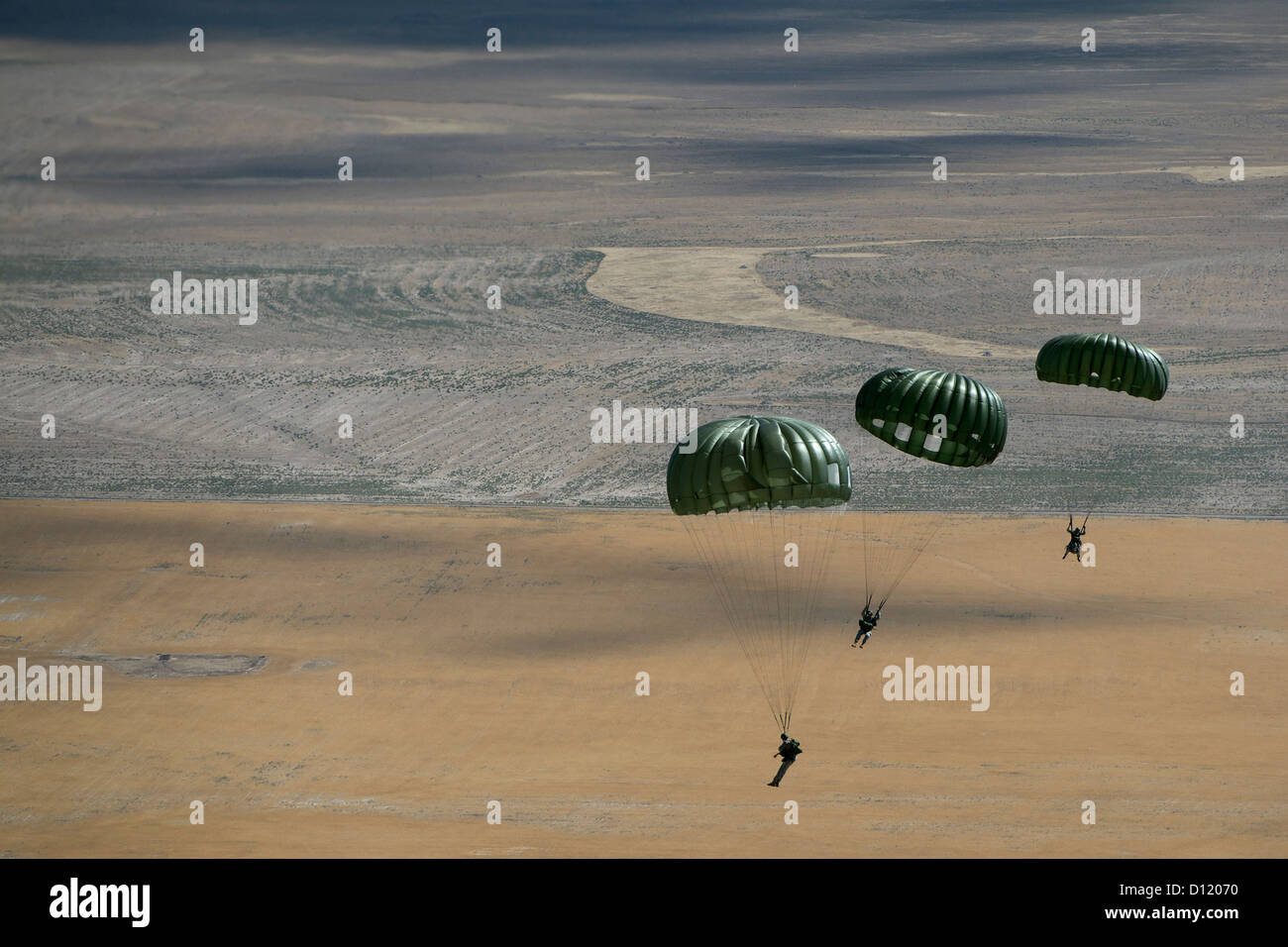 US Army soldiers float over a drop zone September 5, 2012 near Fairfield, Utah during a static line training mission. Stock Photo