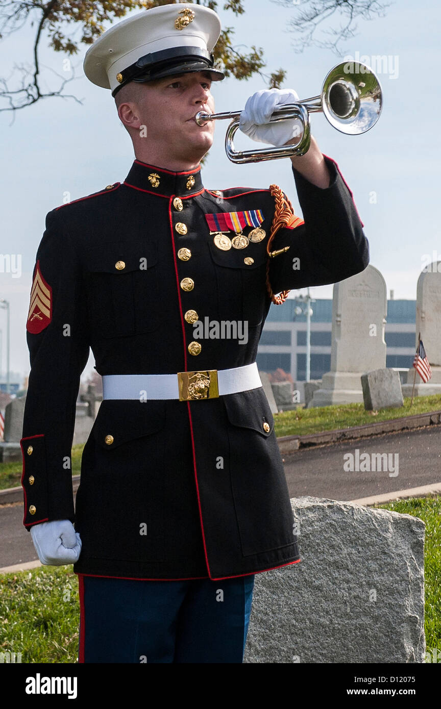 A US Marine Drum & Bugle Corps bugler plays taps during a wreath-laying ceremony at the grave of Major General Ben Fuller November 10, 2012 at the US Naval Academy cemetery in Annapolis, Maryland. Stock Photo