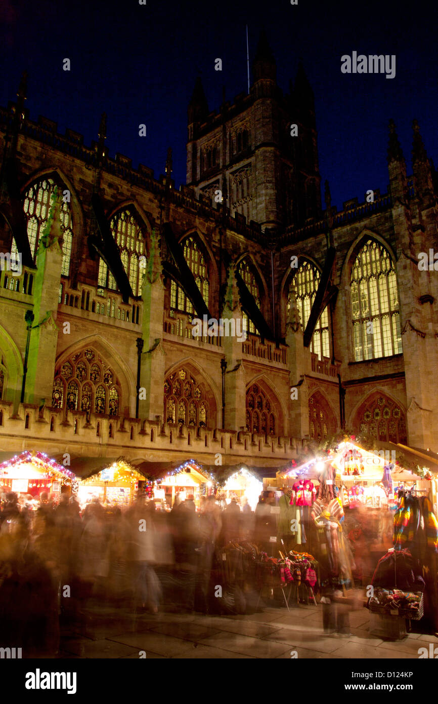 Christmas Market stalls with Bath Abbey in the background at night / twilight / dusk Bath Somerset England UK Stock Photo
