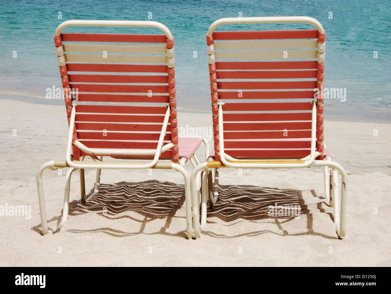 Two Pink Lounge Chairs On A White Sand Beach Cane Garden Bay