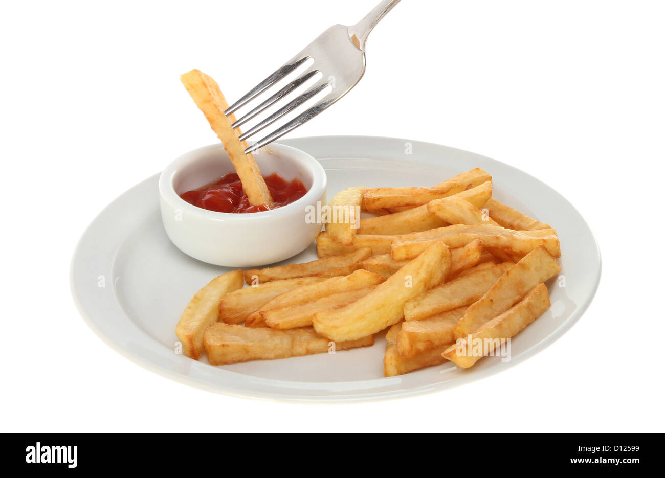 Potato chips on a plate with a chip on a fork dipping in ketchup isolated against white Stock Photo