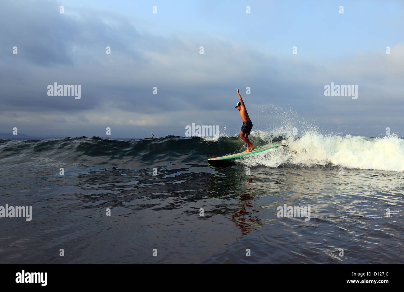 Longboard surfer surfing a wave in Batu Karas on the south coast of